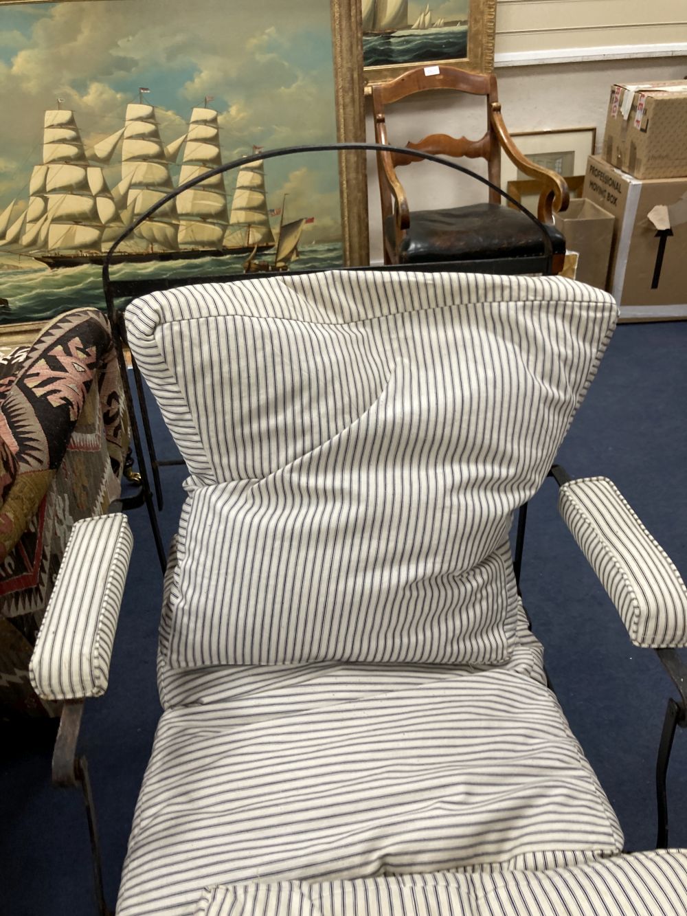 A Victorian wrought iron folding armchair with loose cushion seat and back